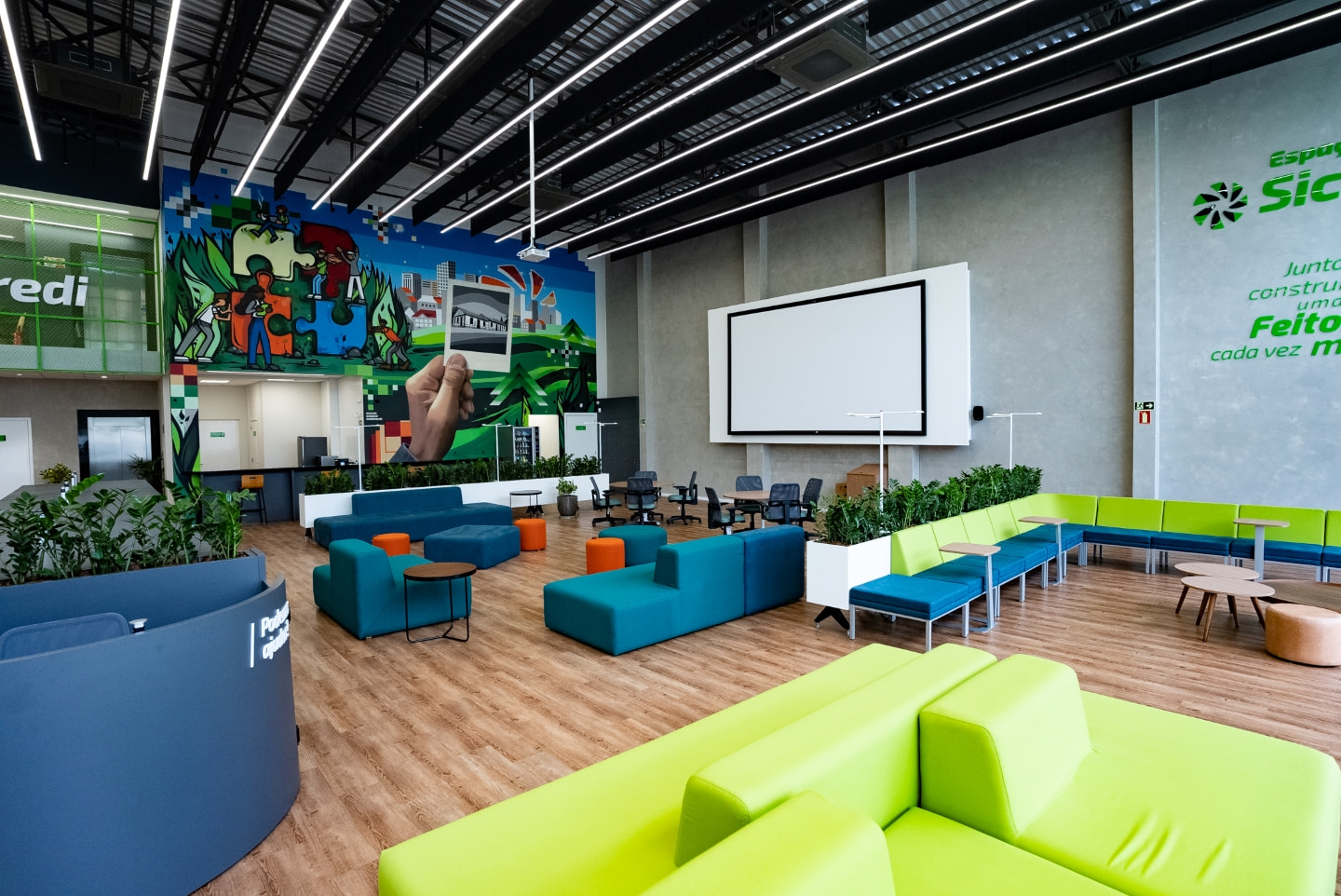 Lounge equipado com sofás, pufes e mesas para reunião